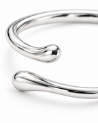 The Nova Open Geometric Band — polished silver-tone open-terminal and smooth bypass macro detail on a pearl-white studio background; reference-based AI visualization.